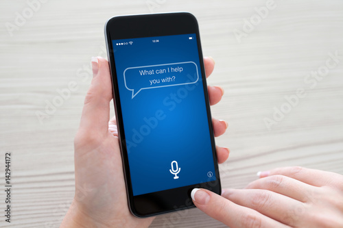 Fotografie Women hands holding phone with app personal assistant on screen