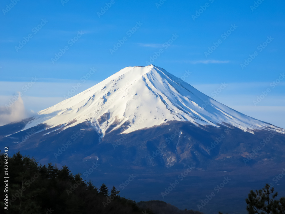 Fuji mountain top filled with white snow and blue sky background
