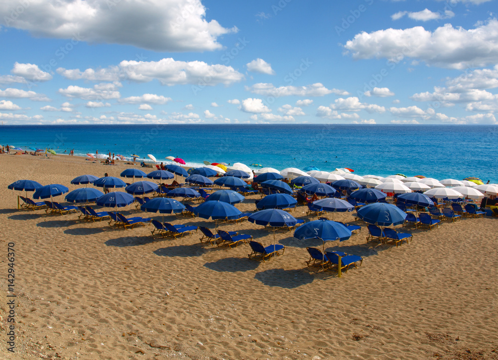 many umbrellas on the beach, symbolic photo for holidays