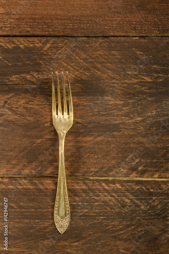 Vintage fork on wooden background with copyspace