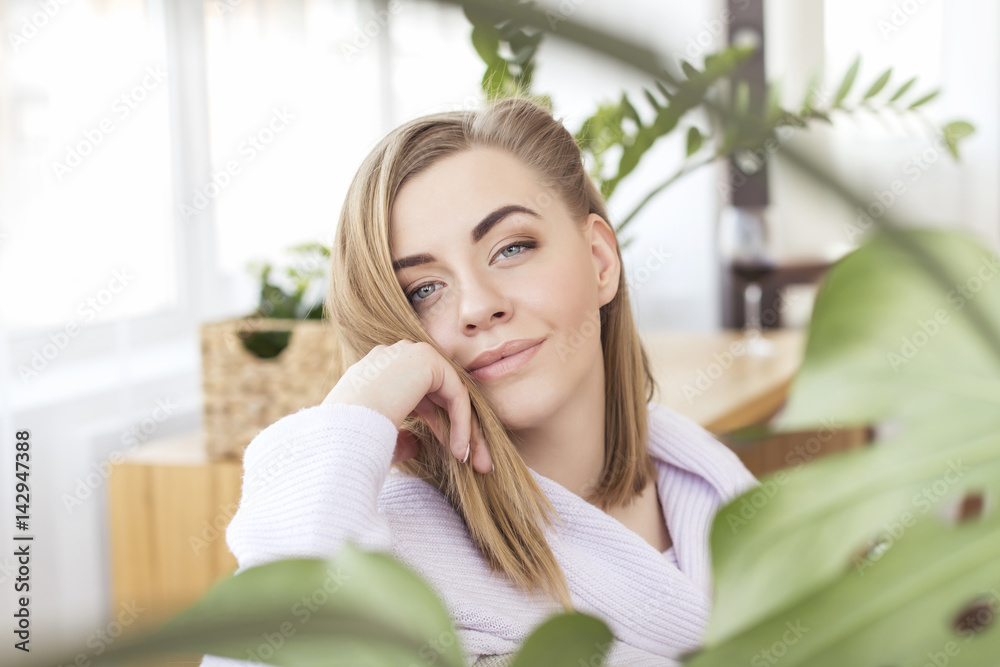 Caucasian young woman at home with plants