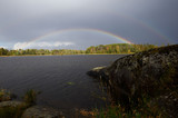 Dark clouds and rainbow after rain on the lake