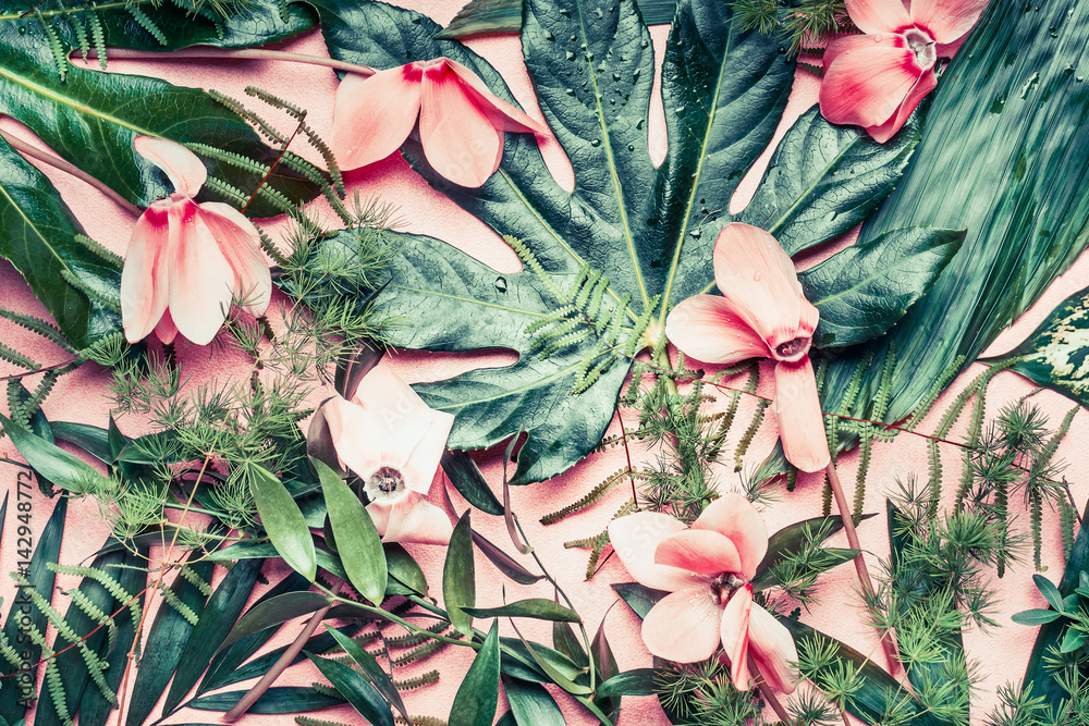 Fototapeta Twórczy układ wykonane z tropikalnych kwiatów i liści palmowych na pastelowym tle różowy, widok z góry, płaskie świeckich