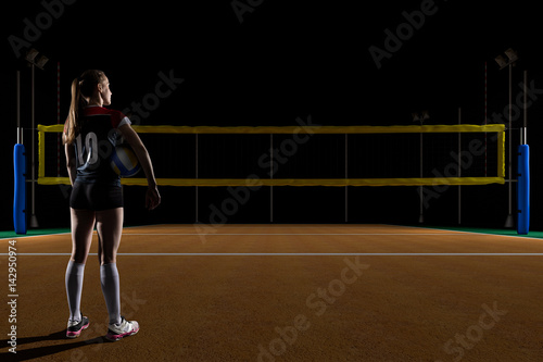 Vászonkép Female volleyball player standing with the volley ball