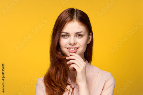 yellow background, happy woman, touch the chin with your hand