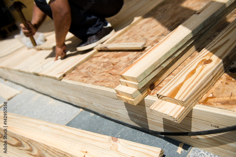 Man laying laminate flooring with tools. Man laying laminate flooring with tools.