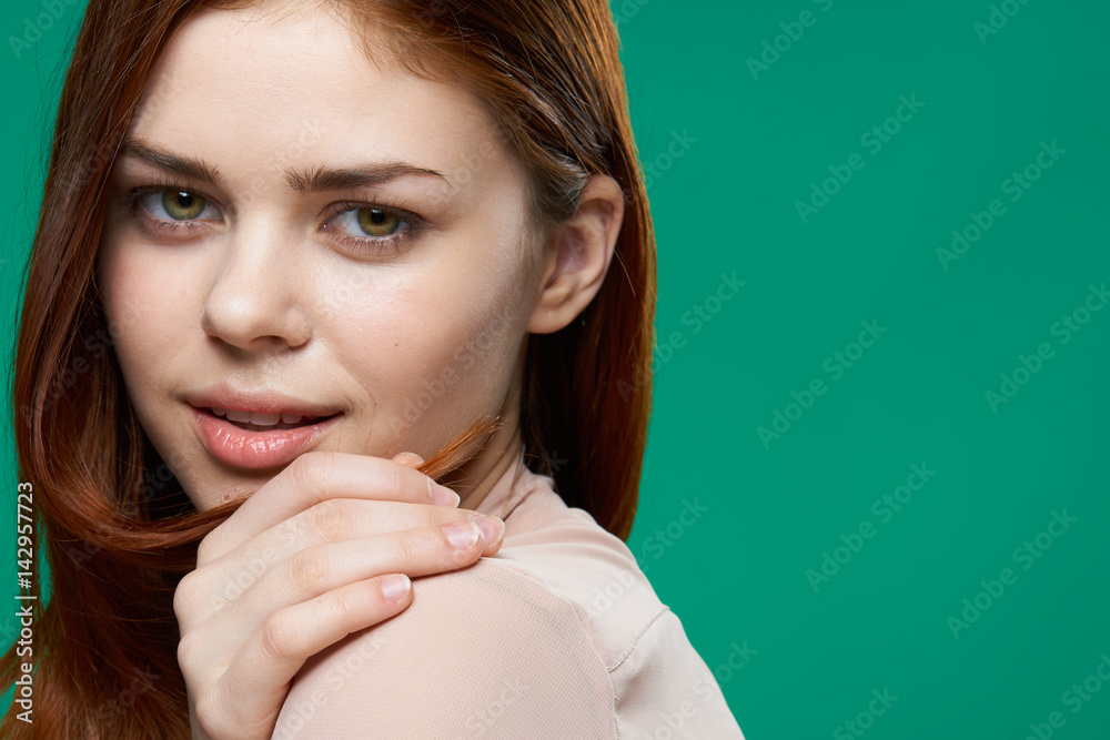 woman on a green background touches her shoulder with her hand woman on a green background touches her shoulder with her hand