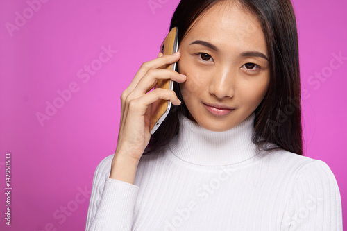 beautiful brunette with a phone looking at the camera