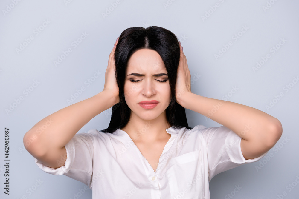 Angry woman with big trouble touching head and covering ears. She does not want to hear anyone now Angry woman with big trouble touching head and covering ears. She does not want to hear anyone now