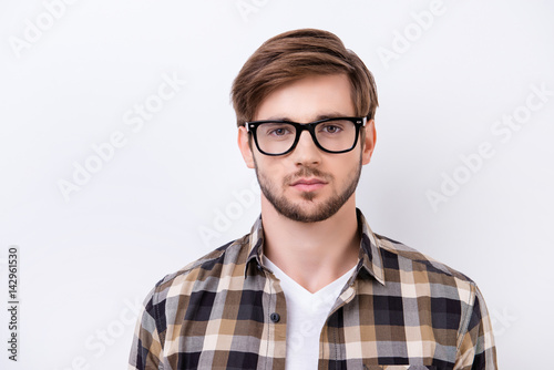 Portrait of smart young confident man in a checked shirt with glasses