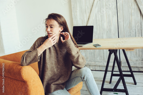 young successful blogger or businesswoman working at home online with laptop and cup of coffee in the morning. Home office in modern scandinavian interior photo