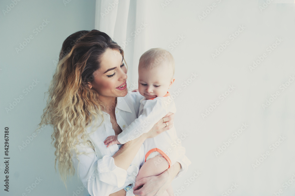 happy family at home. Mother holding baby son in bedroom in cozy weekend morning happy family at home. Mother holding baby son in bedroom in cozy weekend morning