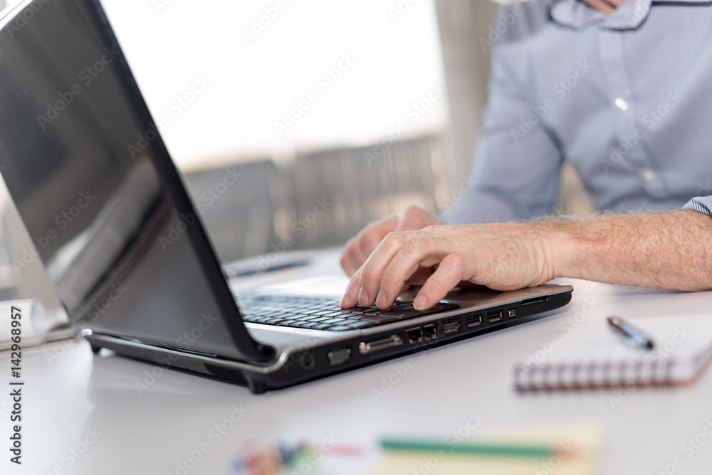 Businessman working on laptop, hard light Businessman working on laptop, hard light