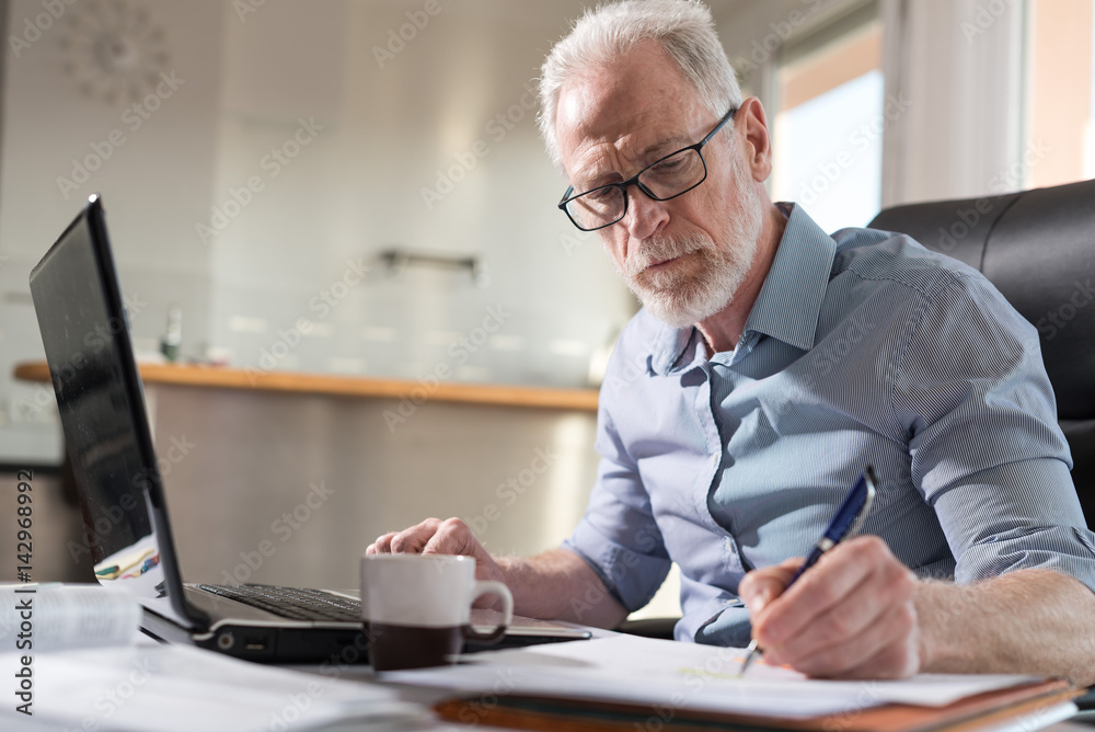 Senior businessman taking notes, hard light Senior businessman taking notes, hard light