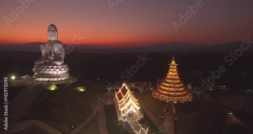 Buddhist Statue Against Colorful Dusk Sky, Aerial Drone Slider Shot
