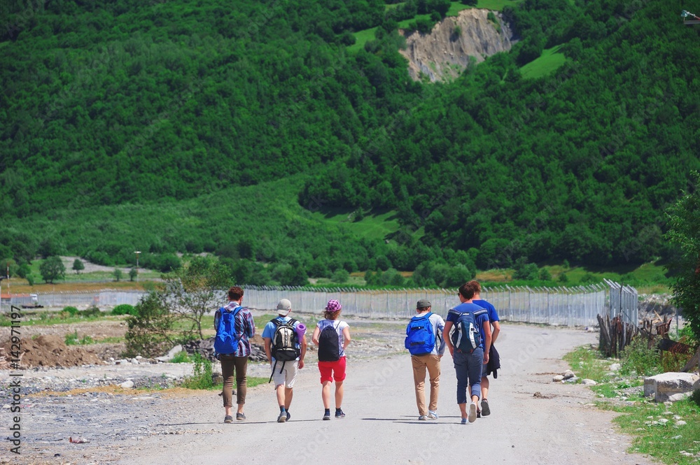 Group of young tourists go to the mountains during the summer holidays. Trekking in Svaneti, Georgia. Summer 2016