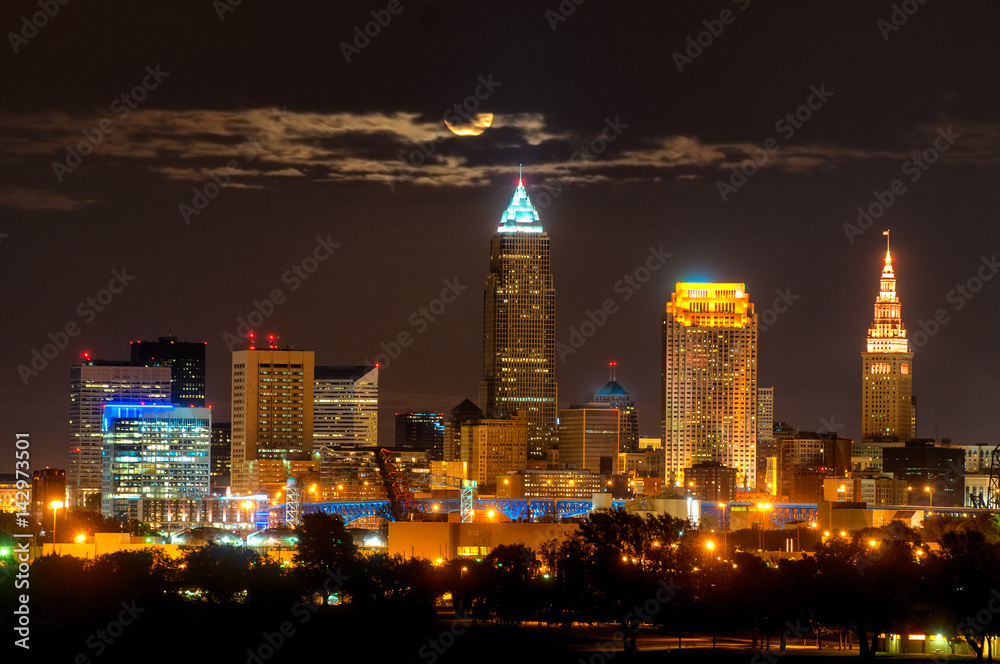 Obraz premium Rising full moon above Cleveland Ohio shining through clouds