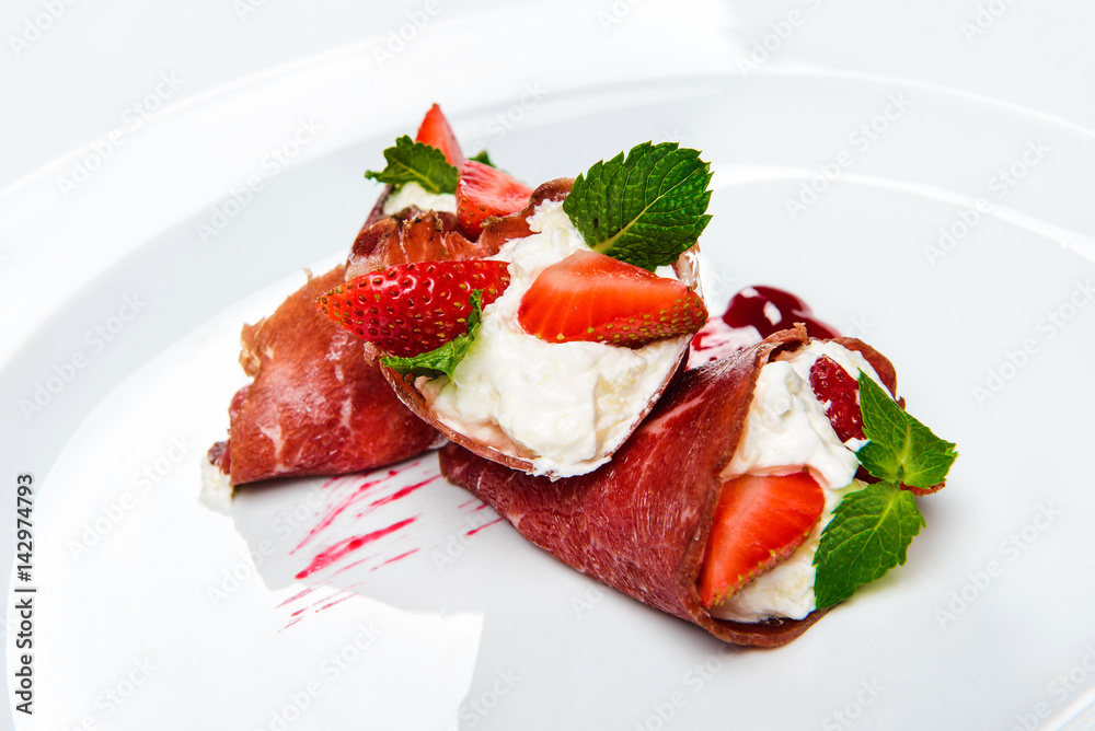 Strawberry and mint in white cream covered with sliced jamon. Strawberry and mint in white cream covered with sliced jamon.
