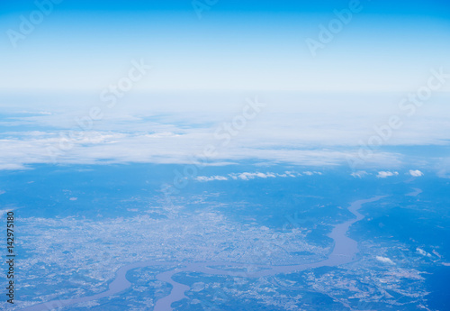Blue sky with white clouds, view from a flying airplane.