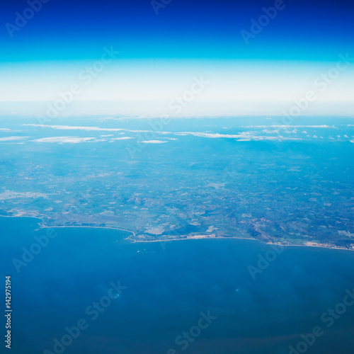 Blue sky with white clouds, view from a flying airplane.