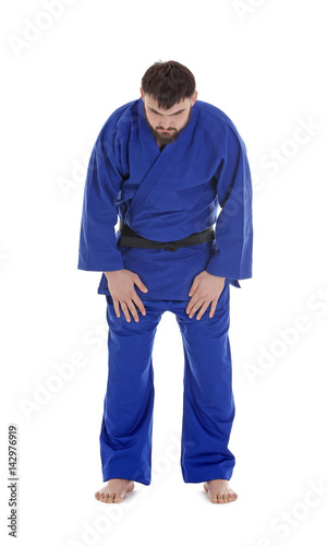 Young sporty man in kimono on white background