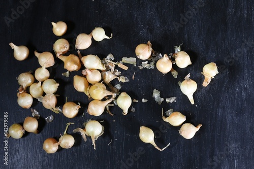 Scattered little onion on black chalk board background.