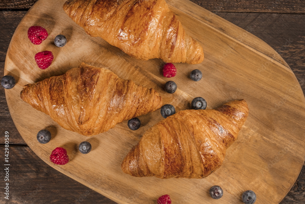 Crunchy French croissants with fresh raspberries and blueberries
