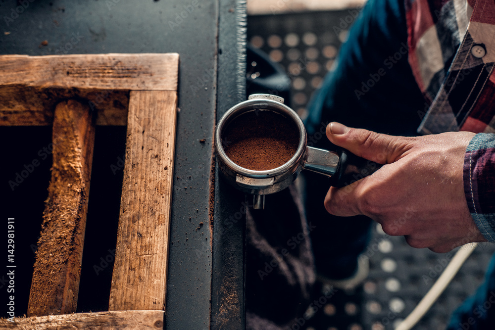  Close up image of a man making coffee.