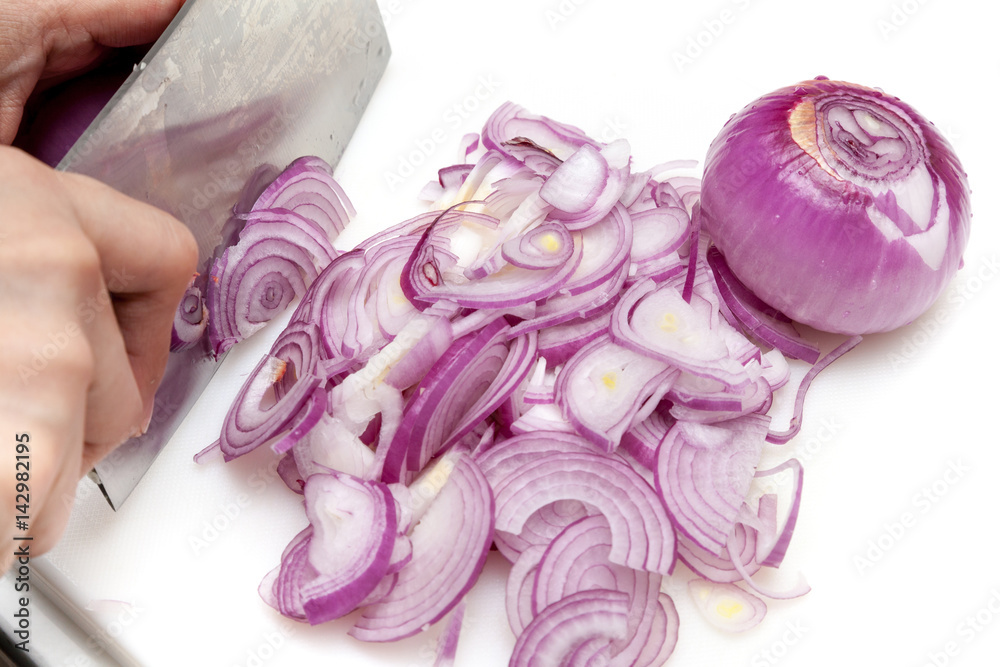 Slicing shallots prepare for cooking on white cutting board