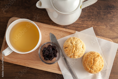 Obraz na płótnie Cups of tea served with scones and homemade blueberry jam on wooden background (selective focus) w salonie