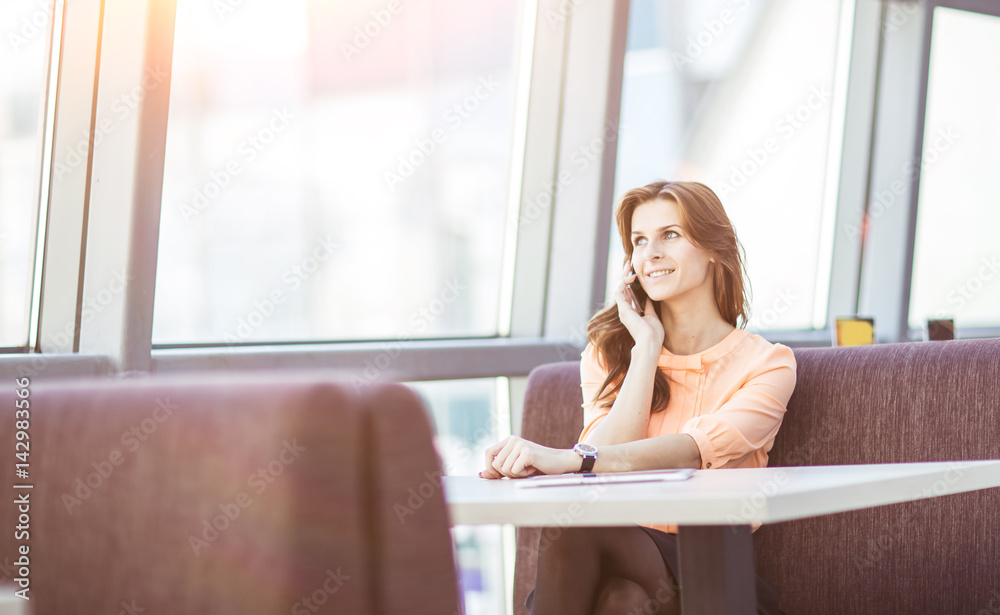 successful business woman talking on the smartphone while sitting at workplace in office successful business woman talking on the smartphone while sitting at workplace in office