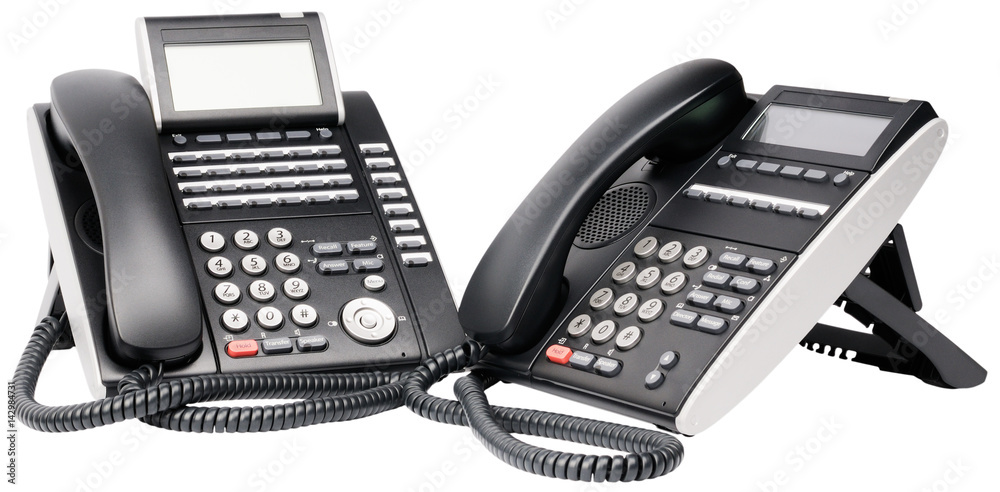 Two office digital multi-button telephone sets with LCD isolated on the white Two office digital multi-button telephone sets with LCD isolated on the white