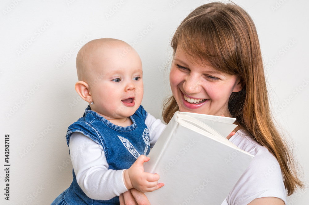 Smiling mother and her child reading a book Smiling mother and her child reading a book