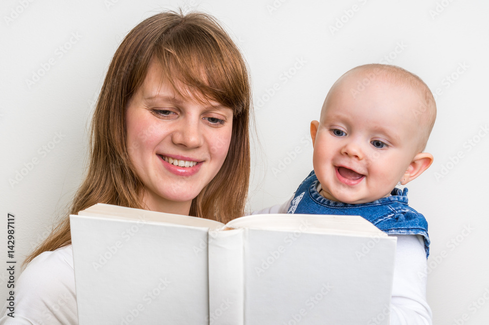 Smiling mother and her child reading a book Smiling mother and her child reading a book