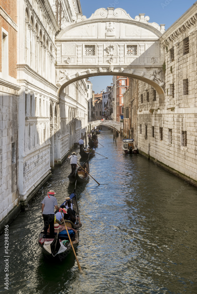 Row of gondolas under the famous Ponte dei Sospiri, Bridge of Sighs in Venice, Italy
