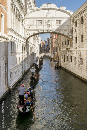 Row of gondolas under the famous Ponte dei Sospiri, Bridge of Sighs in Venice, Italy