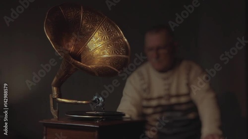 The old man listens to the gramophone