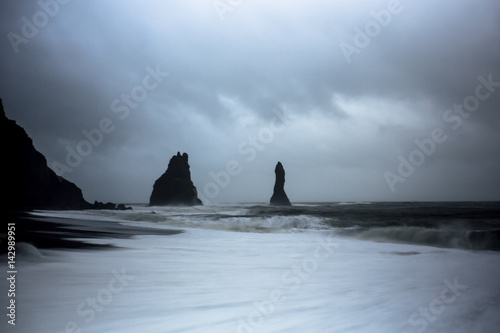 Reynisdrangar are basalt stacks in the stormy North Atlantic, of southern Iceland. Just outside the village, the beach called Reynisfjara is ranked as one of the most beautiful non-tropical beaches.