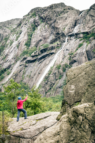 Woman on mountain rock enjoying beautiful view