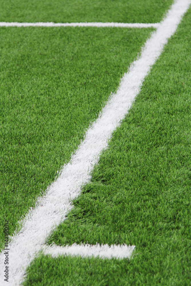 Artificial turf with markings on a football field. Sports background. 