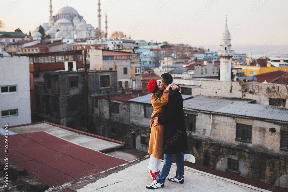 Couple in love on roof in old city Istanbul. Beautiful mosque view on background