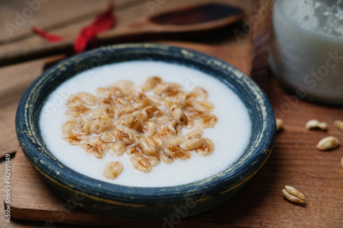 Dish of cereal with milk and wooden spoon 