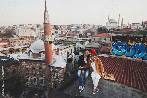 Canvas Print Couple in love sitting  on roof with view of evening Istanbul