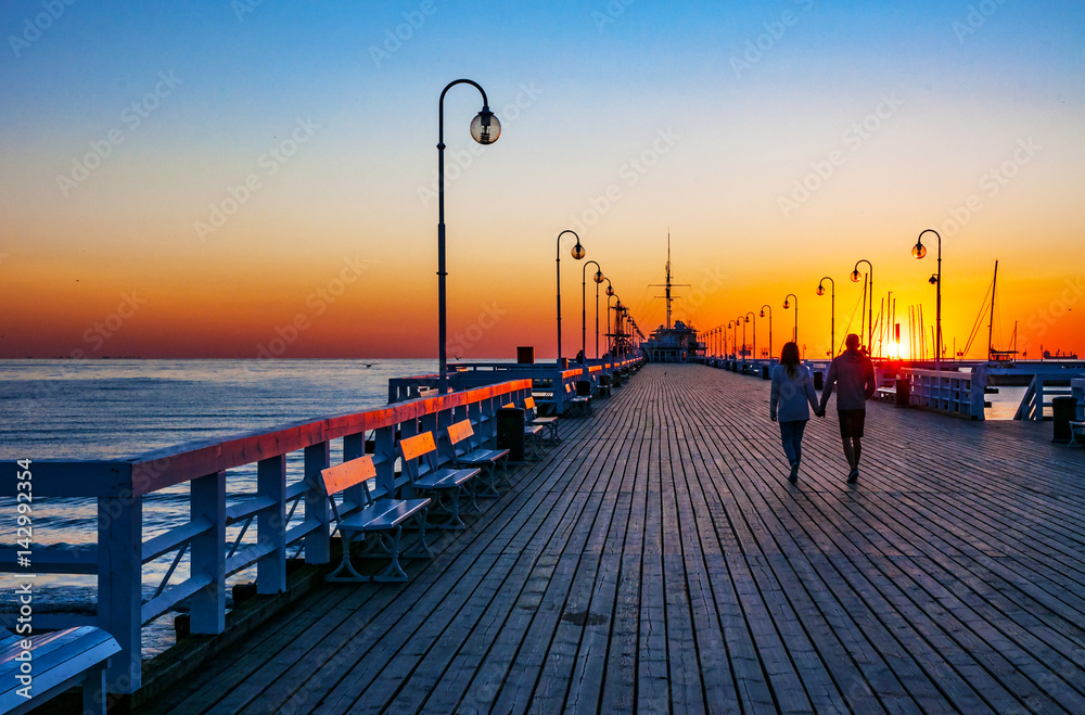 Fototapeta premium Wschód słońca przy drewnianym molo w Sopocie