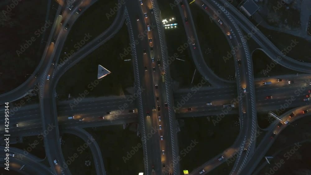 Vertical top down aerial view of traffic on freeway interchange at night Vertical top down aerial view of traffic on freeway interchange at night