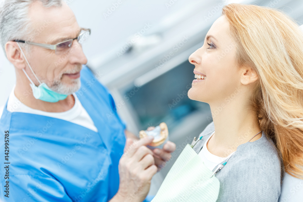 dentist showing jaws model to patient in dental clinic dentist showing jaws model to patient in dental clinic