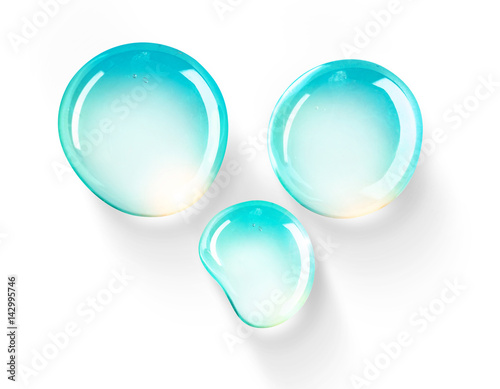 Set of three drops of water beautifully rounded form turquoise color with bright highlights on a white background close-up macro. Light airy drops.