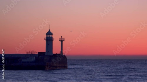 Wallpaper Mural A pier with a flashing lighthouse at dawn. Yalta Crimea. Torontodigital.ca