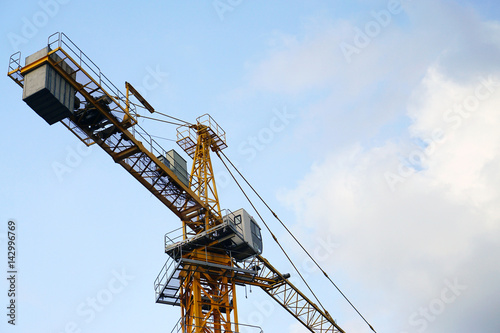 Industrial Construction cranes tower on blue sky background.