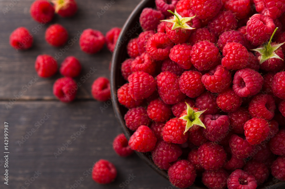 Red fresh raspberries on brown rustic wood background Red fresh raspberries on brown rustic wood background